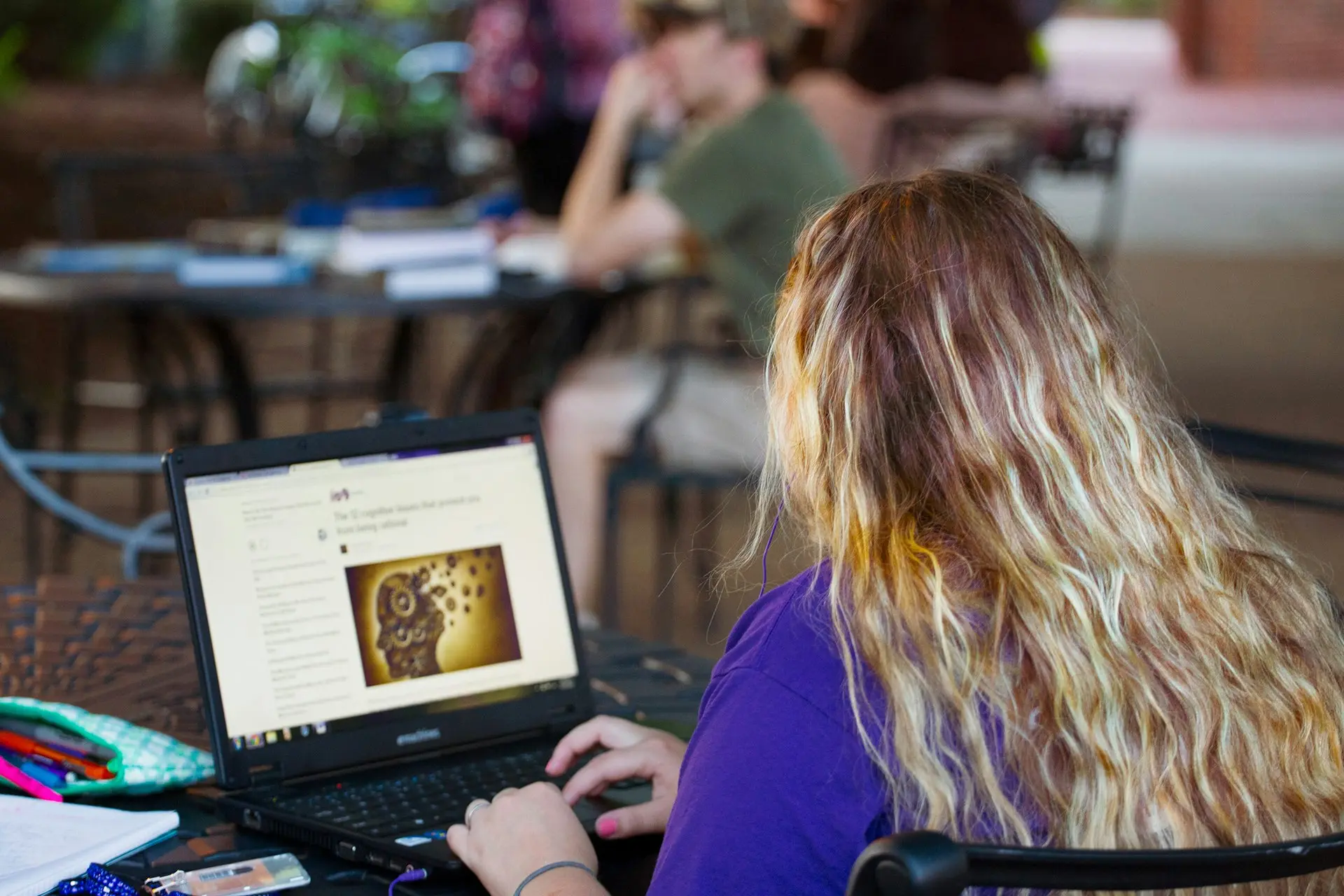 woman in purple shirt using black laptop computer